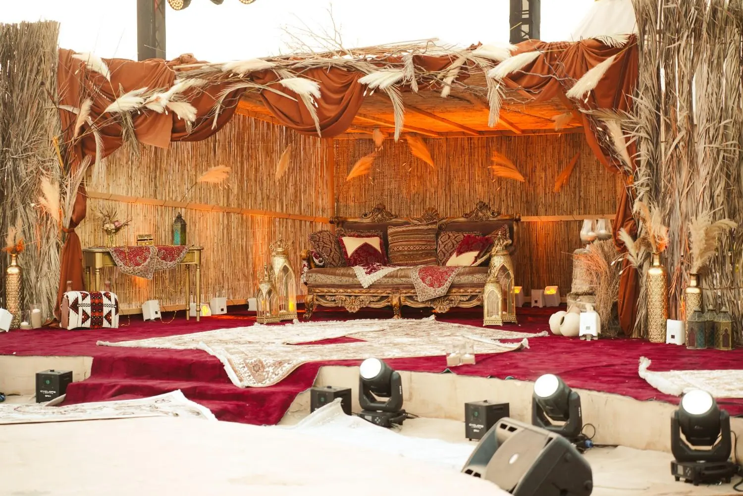Carved majlis sofa with brass lanterns on the wedding stage